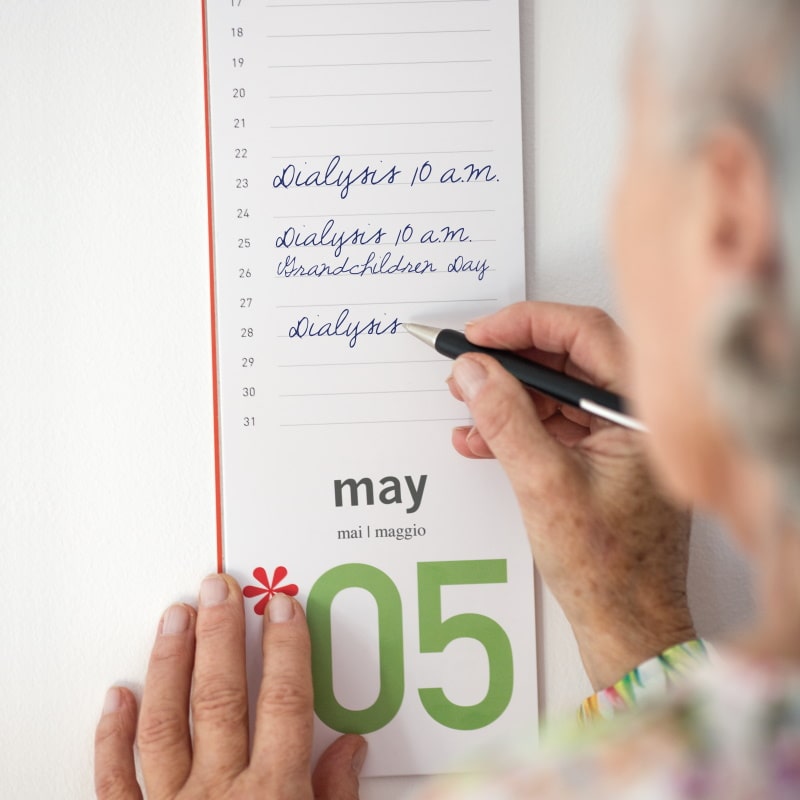 mulher idosa toma notas no seu calendário