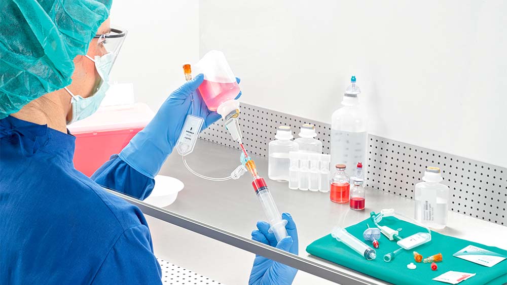 O farmacêutico manipula as seringas na câmara de fluxo laminar