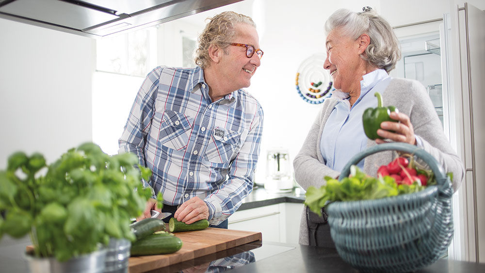 homem e mulher preparam legumes juntos