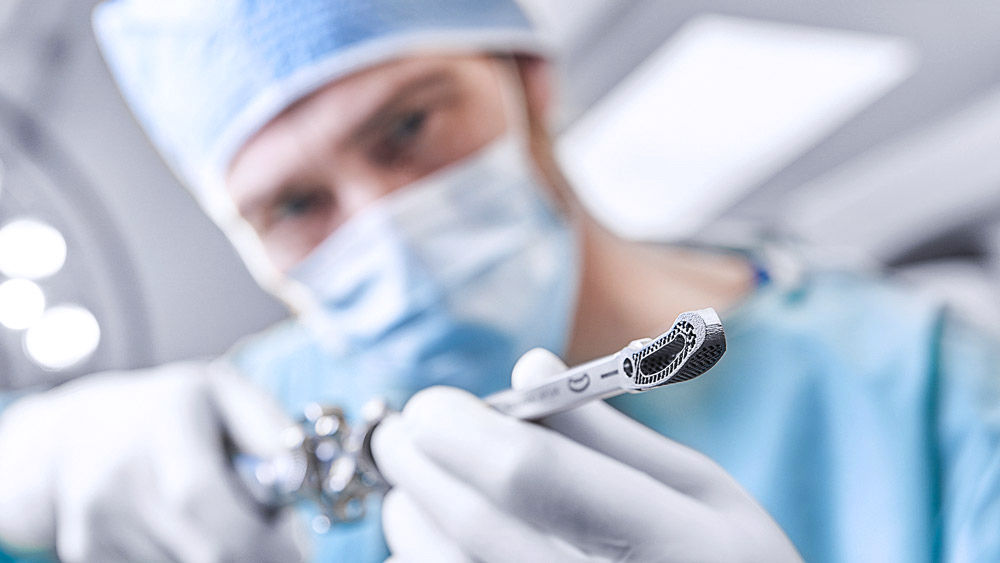 Cirurgião a segurar num instrumento com um dispositivo de fusão intercorporal 3D