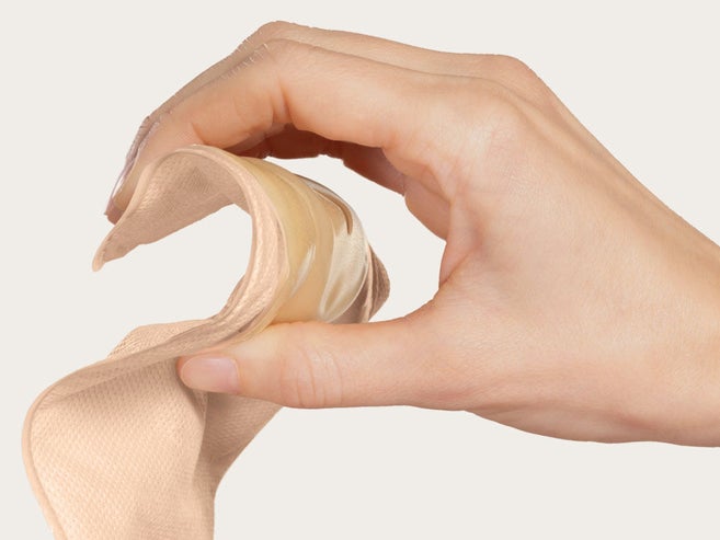 A mão pressiona a placa de um dispositivo com convexidade suave para demonstrar a sua flexibilidade