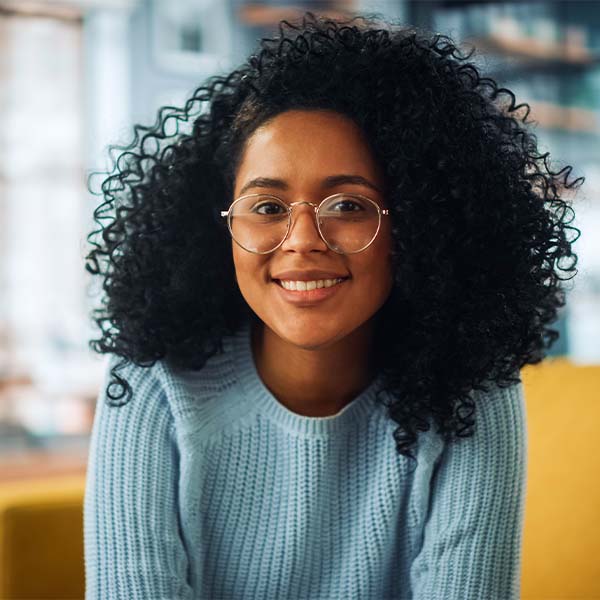 Uma pessoa a usar óculos num fundo verde, irradiando confiança e inteligência. 